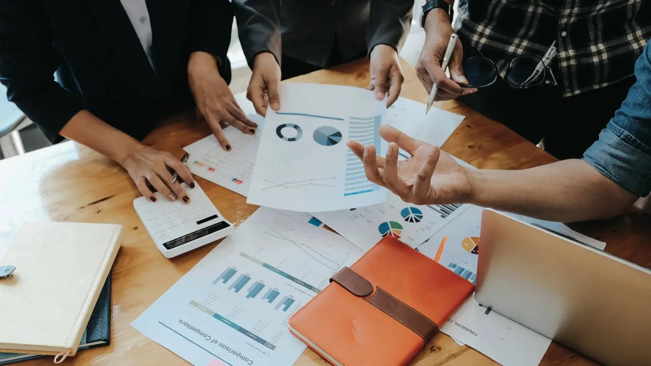 business people look over papers with common valuation methods on a table