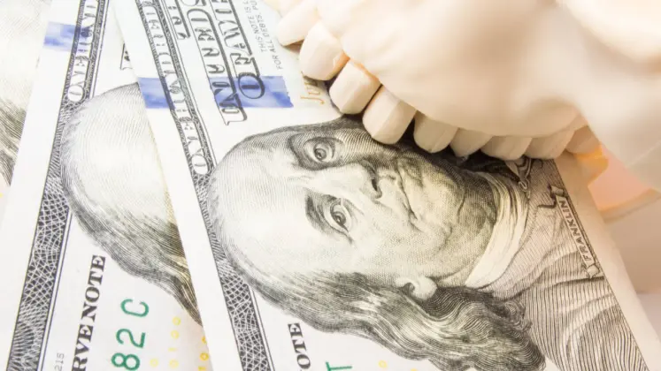 a human skull’s teeth sits on top of money