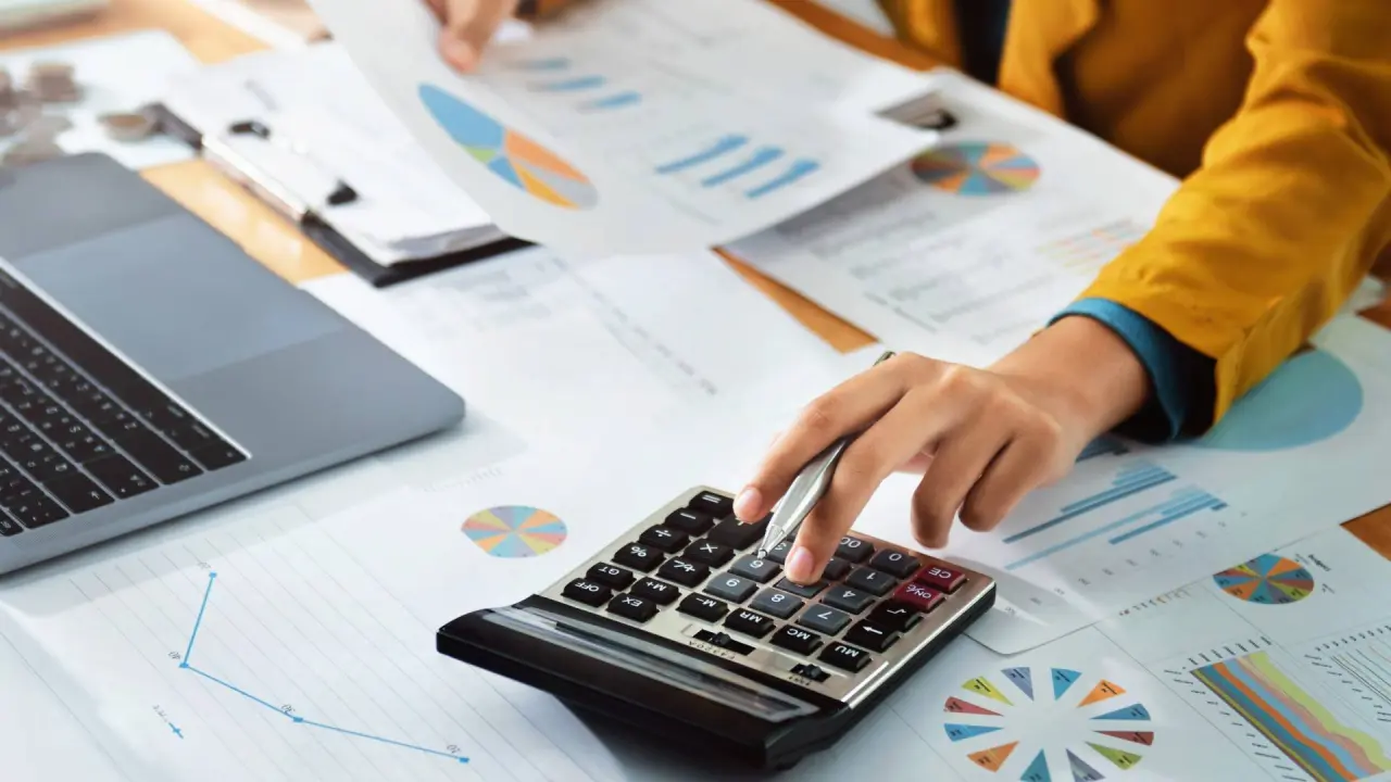 a person calculates finances and debt on a calculator
