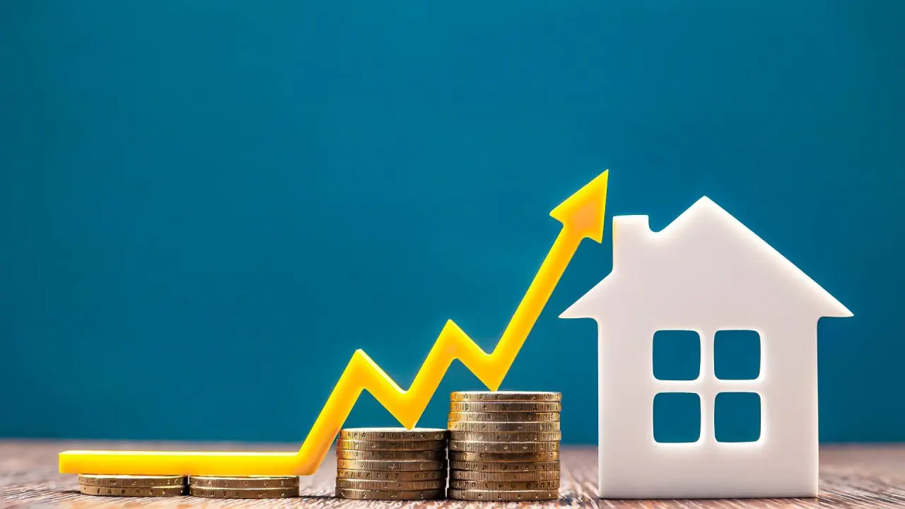 a real estate market graph shows piles of coins next to a toy house with an arrow going up to represent the factors influencing sales prices