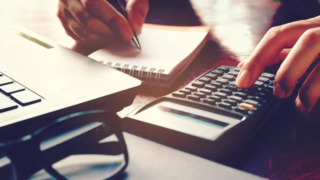 a dentist looks at paperwork to analyze the factors that impact the cost of selling a dental practice